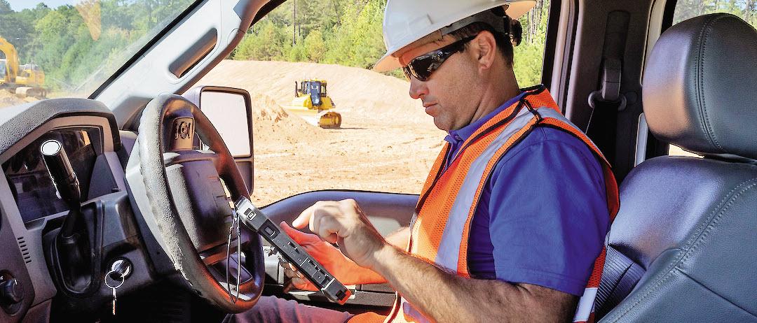 Person on job-site viewing tablet